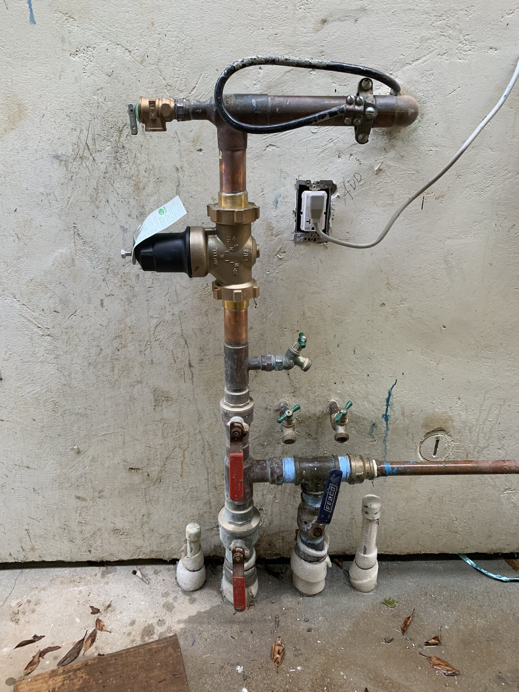 Copper distribution piping with multiple branch stub-outs and ball valves fixed to a framed wall during a whole-house repipe